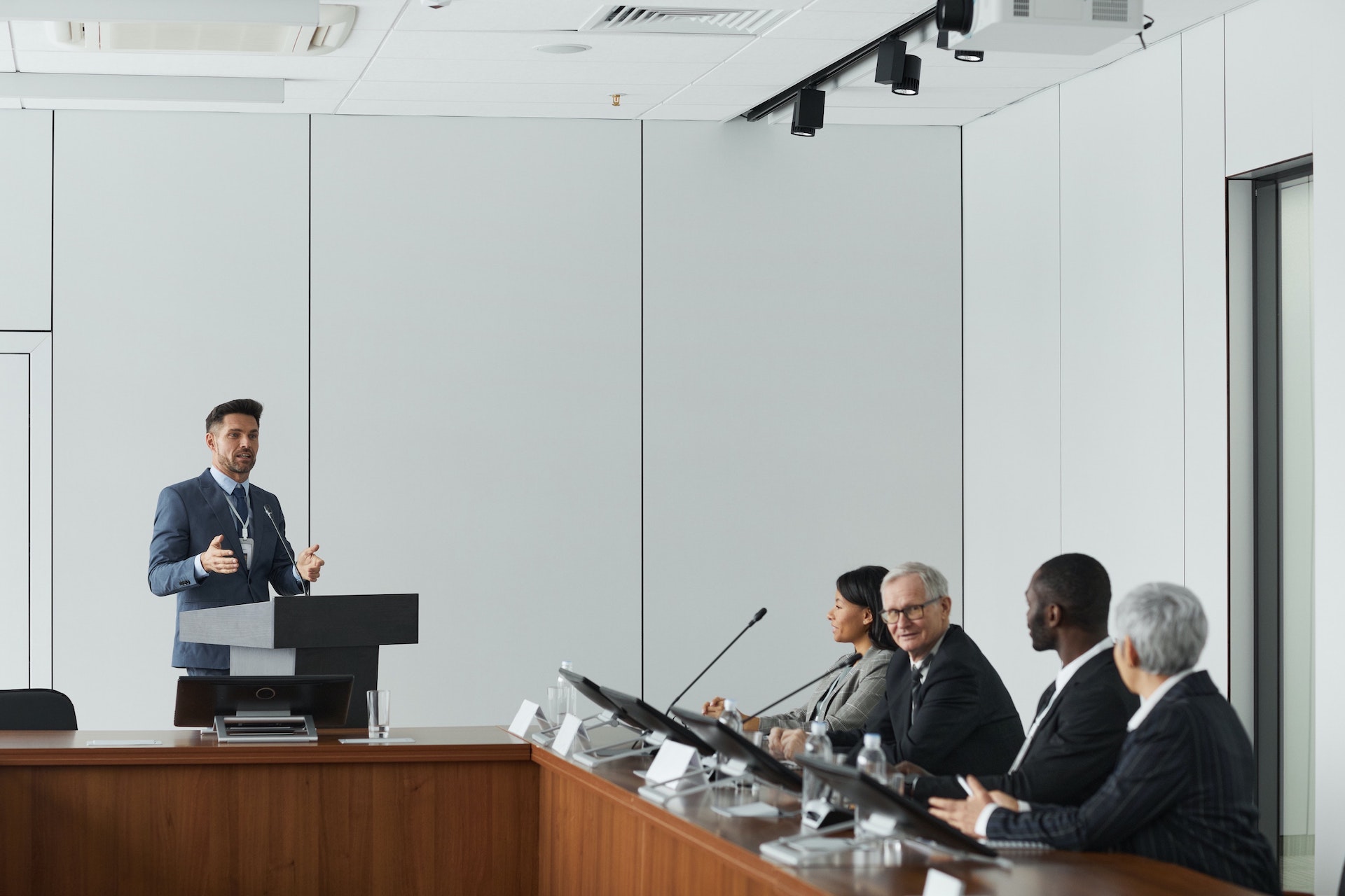 Five regulatory professionals meeting in board room to review clinical study data and submissions for regulatory review.